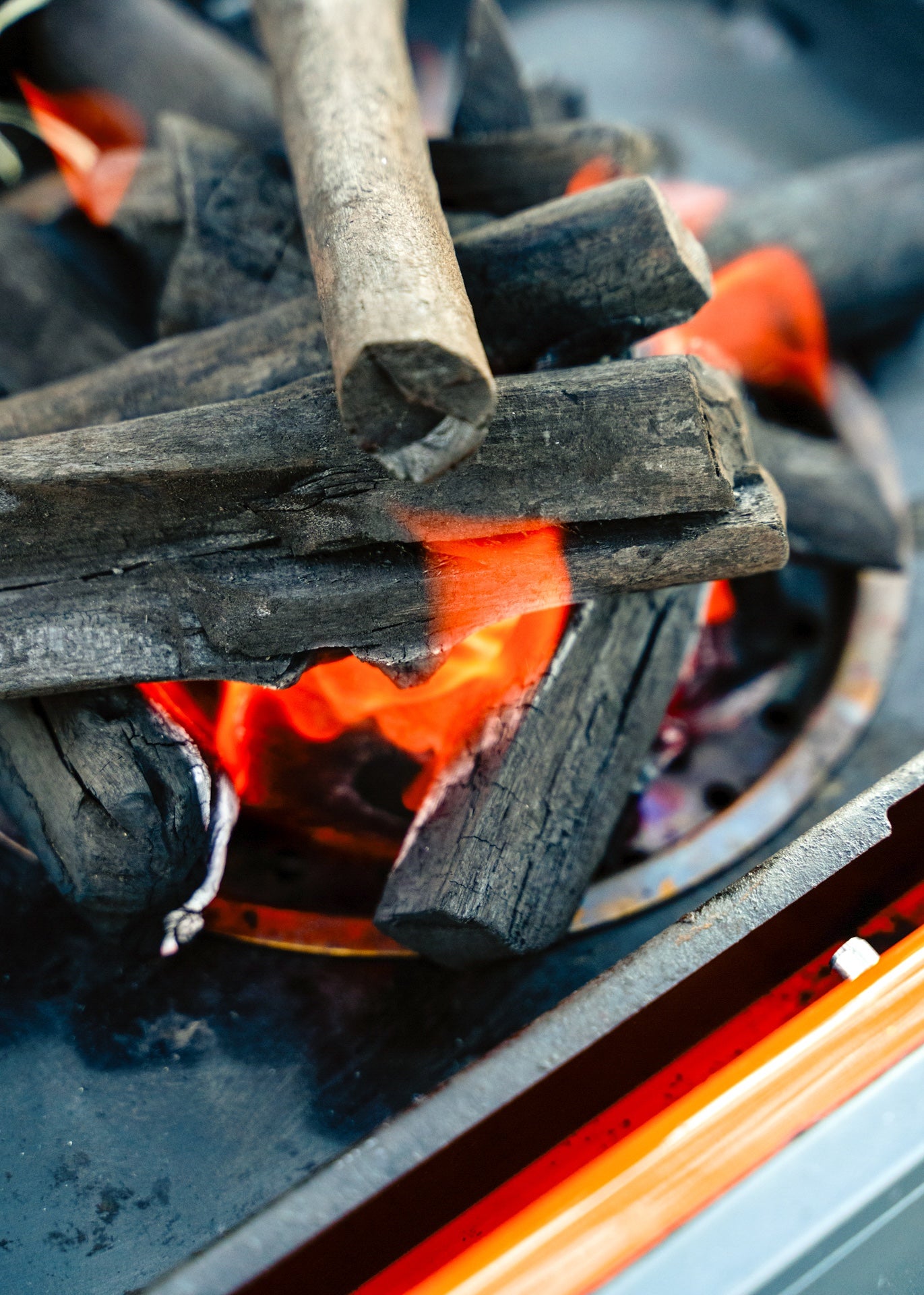 Outdoor BBQ grill with glowing coals and Everdure's Winter Warm-Up Showcase banner, inviting participants to join the BBQ competition and win prizes.